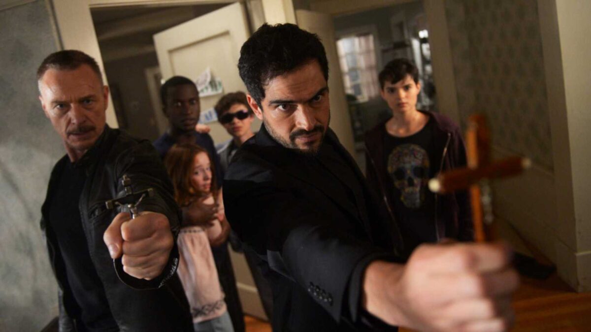 Father Marcus and Father Tomas holding out crosses with several people behind them in The Exorcist