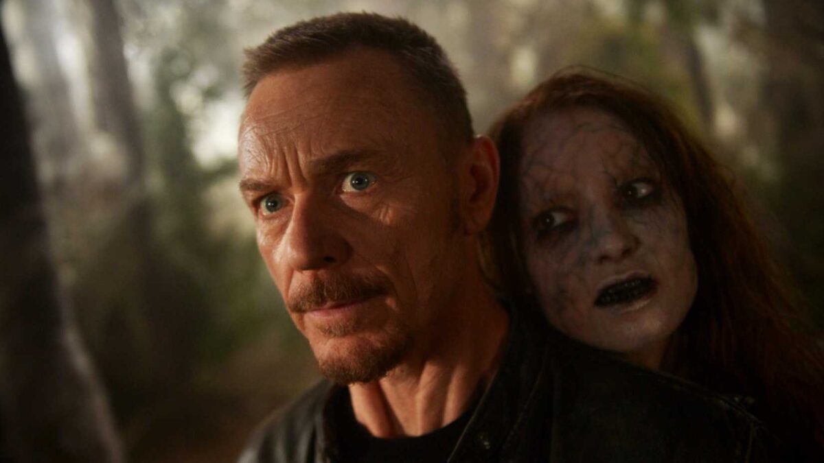 Father Marcus (Ben Daniels) with a ghost behind him in The Exorcist