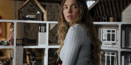 Sydney Sweeney as Millie Calloway looking nervous by a dollhouse in The Housemaid