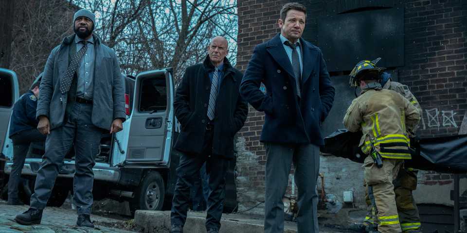Jeremy Renner's Mike walking away from a burned-out building in Mayor of Kingstown season 4