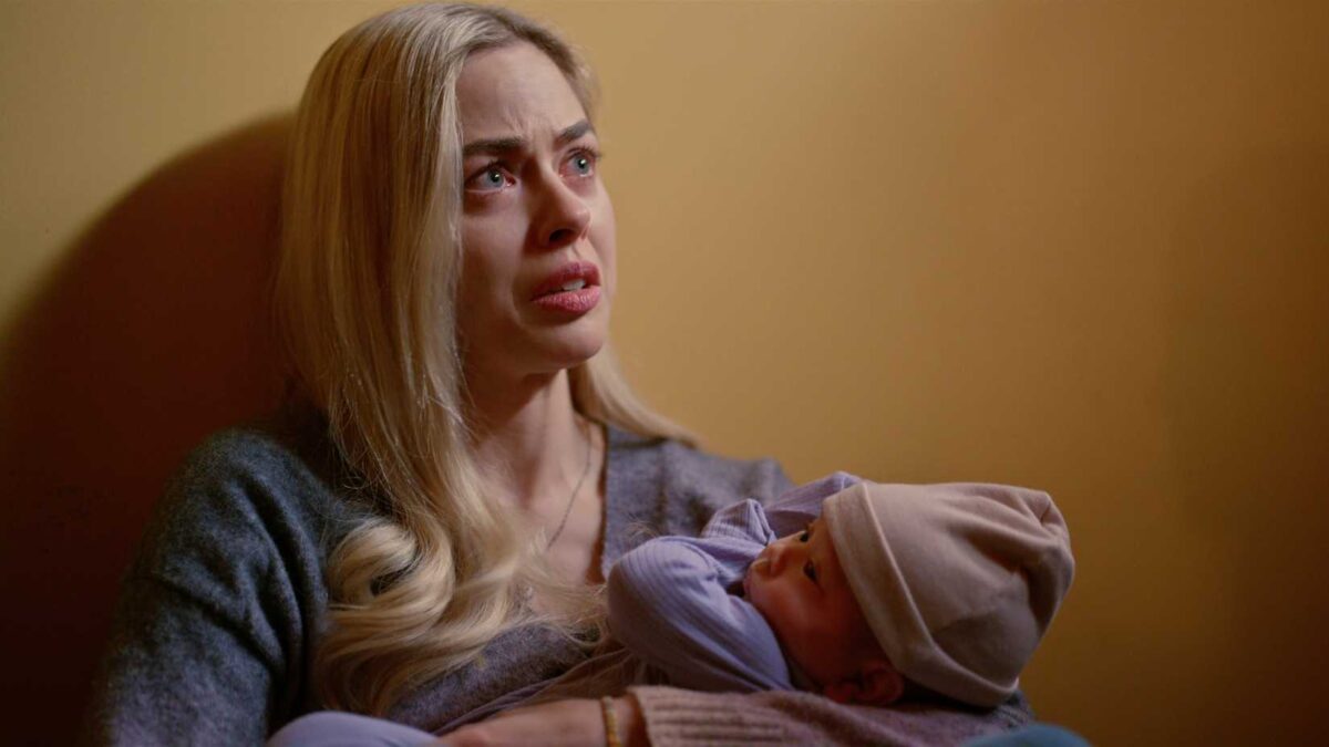 Lizzie holds baby Koko while crying on the floor in Virgin River season 7